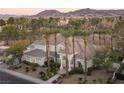 Stunning aerial view of the home, showcasing mature trees and landscaping, set against a mountain backdrop at 1865 Woodhaven Dr, Henderson, NV 89074