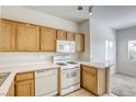 Bright kitchen featuring oak cabinets, white appliances, countertops, and tile flooring at 2117 Echo Bay St # 102, Las Vegas, NV 89128