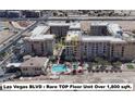 Stunning aerial view of Las Vegas Blvd condo building featuring a community pool and perfectly manicured grounds at 2455 W Serene Ave # 923, Las Vegas, NV 89123