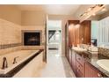 Relaxing bathroom featuring a soaking tub with fireplace, dual vanity, and walk-in closet at 2455 W Serene Ave # 923, Las Vegas, NV 89123