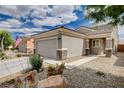 Inviting single-story home with a well-manicured yard, desert landscaping, and a two-car garage at 2621 Ground Robin Dr, North Las Vegas, NV 89084