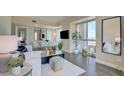 Bright living room with white sofa, glass table, and city view through windows at 2700 Las Vegas Blvd # 2303, Las Vegas, NV 89109