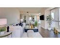 Bright living room with white sofa, glass table, and city view through windows at 2700 Las Vegas Blvd # 2303, Las Vegas, NV 89109