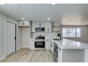 A bright, modern kitchen featuring white cabinetry, quartz countertops, and stainless steel appliances at 3330 Rio Grande St, Las Vegas, NV 89115