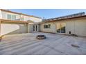 A spacious patio with a fire pit and stucco walls, perfect for outdoor entertaining at 3719 Centennial Cir, Las Vegas, NV 89121