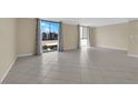 Bright living room featuring large windows, tile flooring, and neutral paint at 3930 University Center Dr # 202, Las Vegas, NV 89119