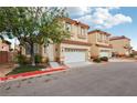 Residential street featuring townhomes with neutral exteriors, terracotta roofs, and two-car garages at 5286 Monterey Park Cir, Las Vegas, NV 89146