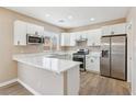 Well-lit kitchen featuring white cabinets, stainless steel appliances, and elegant marble-style countertops at 5286 Monterey Park Cir, Las Vegas, NV 89146