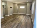 A bright living room featuring wood-look floors and a large window providing natural light at 5286 Monterey Park Cir, Las Vegas, NV 89146