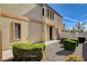 Landscaped front yard leading to a home featuring a charming exterior with a light tan facade at 5524 Overlook Valley St, North Las Vegas, NV 89081