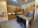 Kitchen featuring granite counters, stainless appliances, and kitchen island with breakfast bar seating at 5832 Elphin Ct, North Las Vegas, NV 89031