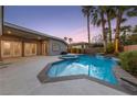 Inviting backyard pool and spa featuring lush landscaping and a covered patio, perfect for outdoor entertaining at 616 Canyon Brook Pl, Las Vegas, NV 89145