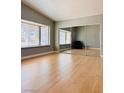 Bright bedroom with a large window, mirrored closet doors and light wood flooring at 6786 Grandola Dr, Las Vegas, NV 89103