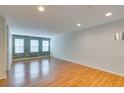 Spacious living room featuring wood floors, three large windows, and neutral paint at 9050 W Tropicana Ave # 1053, Las Vegas, NV 89147