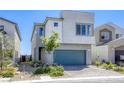 Modern two-story home with gray stucco, a blue-green garage door, and low maintenance front yard at 9772 Alpine Style Dr, Las Vegas, NV 89166