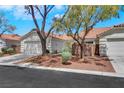 A cozy single-story house with a two-car garage nestled among mature trees at 9962 Catalina Canyon Ave, Las Vegas, NV 89147
