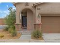 Home featuring covered entry with stone columns and desert landscaping at 10728 Brewster Bay St, Las Vegas, NV 89179