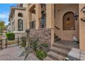 Inviting front entrance with stone accents, decorative columns, and stylish outdoor decor at 1161 Sax Fifth Ave, Henderson, NV 89052