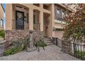 Charming facade with stone accents, wrought iron details, and lush greenery leading to the front door at 1161 Sax Fifth Ave, Henderson, NV 89052