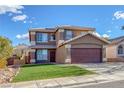 Two-story home featuring a brown facade, well-kept lawn, and a two-car garage at 1481 Rancho Ridge Dr, Henderson, NV 89012