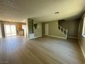 Open concept living area with laminate floors, connecting to the kitchen and stairs to the bedrooms at 173 Greenbriar Townhouse Way, Las Vegas, NV 89121