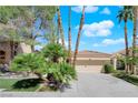 Beautiful single-story home with a well-maintained lawn, mature trees, and a spacious driveway leading to a two-car garage at 1848 Indian Bend Dr, Henderson, NV 89074