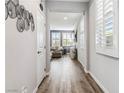 Inviting hallway with wood-look flooring leading to a comfortable living area with gray walls and plantation shutters at 3096 Cipro Ave, Las Vegas, NV 89141
