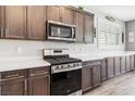 A lovely kitchen featuring wooden cabinets, stainless steel appliances, and white quartz countertops at 3096 Cipro Ave, Las Vegas, NV 89141