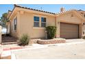 Single car garage featuring neutral paint with manicured desert landscaping in front yard at 31 Via Mantova # 1, Henderson, NV 89011
