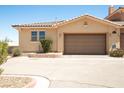 Single car garage featuring neutral paint with manicured desert landscaping in front yard at 31 Via Mantova # 1, Henderson, NV 89011