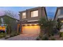 Two-story home with tan stucco, brick accents, and manicured landscaping at 397 Purple Sandpiper St, Las Vegas, NV 89138