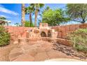 Cozy outdoor fireplace and seating area, set against a decorative block wall, perfect for relaxation at 5005 Justice Creek Ave, Las Vegas, NV 89131