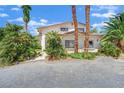 Exterior view of the home with many palm trees at 5890 W Patrick Ln, Las Vegas, NV 89118