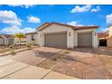 Front exterior of a house with a brick driveway, two-car garage, desert landscaping, and a red tile roof at 647 Quarry Pass, Mesquite, NV 89034