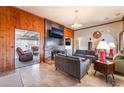 Cozy living room with wood-paneled walls, a stone fireplace, and views into the adjacent sunroom at 650 Arizona St, Boulder City, NV 89005