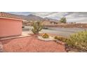 Front yard featuring low-water landscaping with decorative rock, cacti, and a view of the mountains at 7140 Pascal Dr, Las Vegas, NV 89156