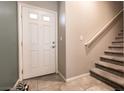 Home entryway featuring a white front door with glass panes and a view of the staircase leading to the upper level at 7721 Sheliak St, North Las Vegas, NV 89084