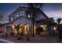 Exterior of a two-story house at dusk highlighting the architecture, landscaping, and a two car garage at 7878 Brianna Cheerful Ave, Las Vegas, NV 89178