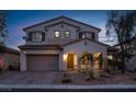 Exterior dusk shot of a two-story home showcasing landscape, tile roof, shutters, and two-car garage at 7878 Brianna Cheerful Ave, Las Vegas, NV 89178
