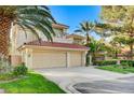 Attractive two-story house showcases a red tile roof, lush landscaping, and a wide driveway leading to an attached two-car garage at 8051 Castle Pines Ave, Las Vegas, NV 89113