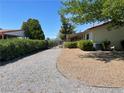 Gravel-covered backyard area with mature trees, a fenced perimeter, and convenient access points to the property at 881 E Calvada Blvd, Pahrump, NV 89048