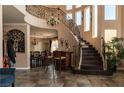 Grand foyer featuring a curved staircase and decorative ironwork at 9012 Alpine Peaks Ave, Las Vegas, NV 89147