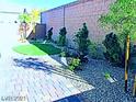 Backyard features drought-tolerant landscaping, gravel, plants, and a putting green at 95 Palm Park Ct, Las Vegas, NV 89183
