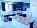 Modern kitchen with stainless steel appliances, granite countertops, and island with breakfast bar at 95 Palm Park Ct, Las Vegas, NV 89183