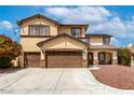 A tan two story home with a three car garage and manicured landscape at 9604 Windom Point Ave, Las Vegas, NV 89129