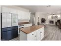 A kitchen that opens to a living room with white cabinets and stainless steel appliances at 9604 Windom Point Ave, Las Vegas, NV 89129