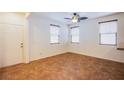 Spacious living room featuring tile flooring, ceiling fan, and multiple windows at 961 Wembly Hills Pl, Henderson, NV 89011