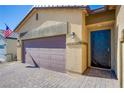Close-up of a home featuring a brick driveway, two car garage, and inviting front door at 10281 Sequoia Falls Pl, Las Vegas, NV 89149