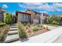 Beautiful modern home featuring stone accents, desert landscaping, and a private two-car garage at 10313 Jade Point Dr, Las Vegas, NV 89135