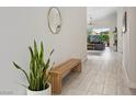 Bright entryway featuring light tile flooring, a modern wood bench, and views into the living room at 11813 Pippa Ave, Las Vegas, NV 89138